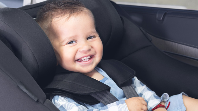 Toddler boy in car seat looking at camera