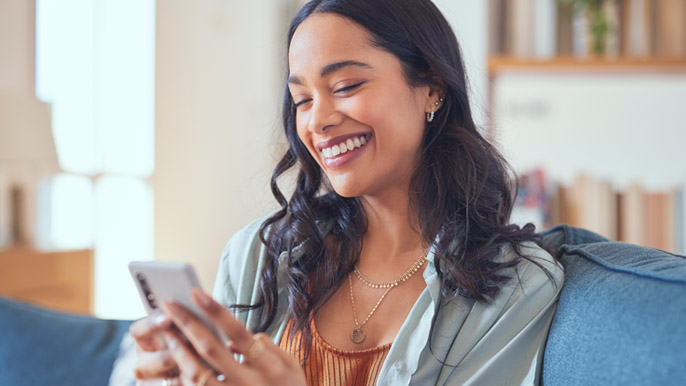 Young mom smiling while looking at phone